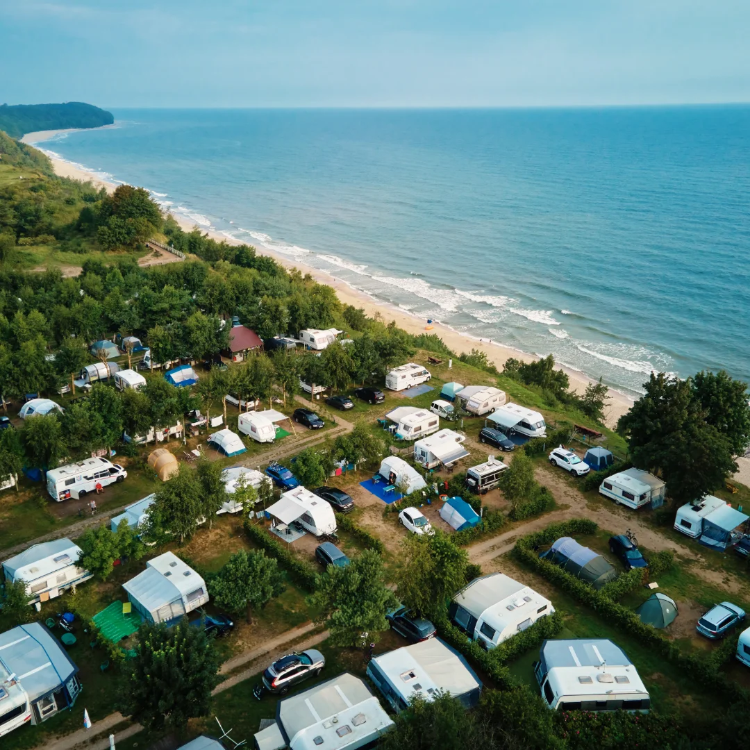 Campingplatz mit Wohnmobilen und Zelten oberhalb der Ostseeküste, Luftaufnahme